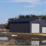 Large metal black storage unit sits on roadside.